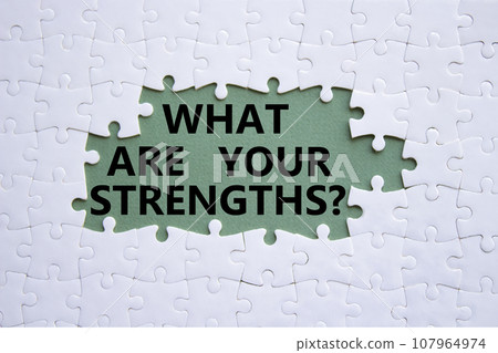 What are your Strengths symbol. White puzzle with words What are your Strengths. Beautiful grey green background. Business concept. Copy space. 107964974