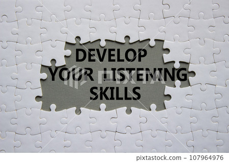 Listening skills symbol. Concept word Develop active listening skills on white puzzle. Beautiful grey background. Business and Develop active listening skills concept. Copy space Listening skills symbol. Concept word Develop active listening skills on white puzzle. Beautiful grey background. Business and Develop active listening skills concept. Copy space 107964976
