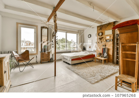 a bedroom with a bed, desk, chair and television set in the corner of the room is very white 107965268