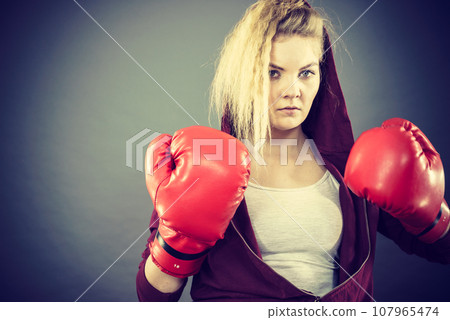 Angry woman wearing boxing gloves 107965474