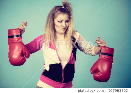 Disgusted woman holding boxing glove Disgusted woman holding boxing glove 107965502