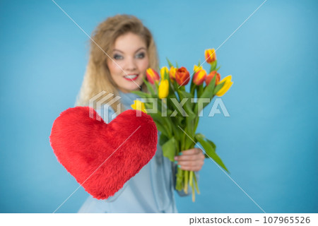 Woman holds tulips and red heart Woman holds tulips and red heart 107965526