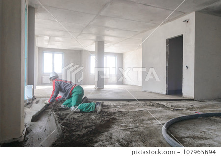 A builder in work clothes is doing his job 107965694