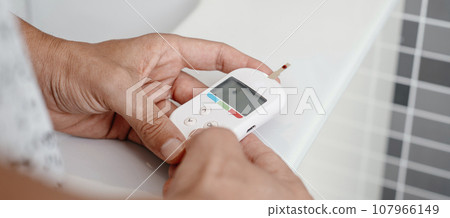 is measuring his blood glucose level, banner format 107966149