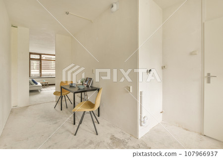 an empty room with a desk and chair in the corner next to a door that has been painted white on it an empty room with a desk and chair in the corner next to a door that has been painted white on it 107966937