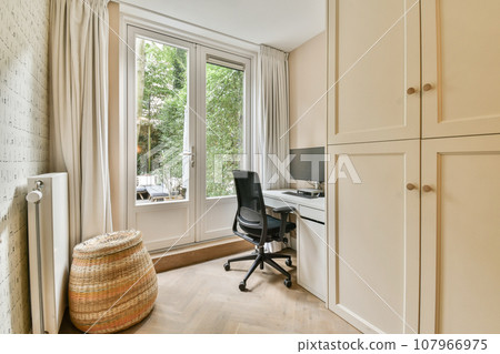 a room with a desk, chair and computer on the floor in front of a window that looks out onto trees a room with a desk, chair and computer on the floor in front of a window that looks out onto trees 107966975