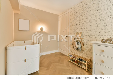 an empty room with white furniture and wallpapers on the walls there is a baby's cribt 107967078