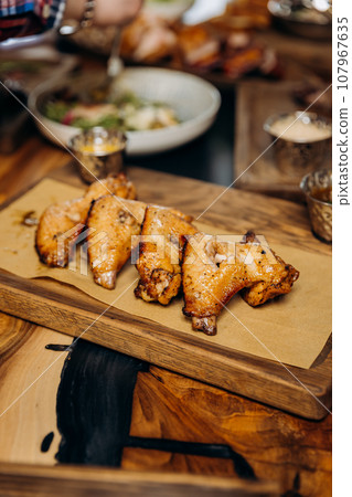 Buffalo barbecue chicken wings with sauce and beer on board. Fast food concept. Beer appetizer 107967635