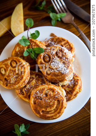 Cooked fried round pancakes with quince filling on a wooden table Cooked fried round pancakes with quince filling on a wooden table 107967875