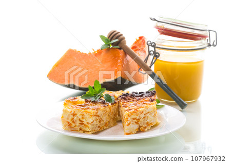 Cooked cottage cheese casserole with pieces of pumpkin inside. 107967932