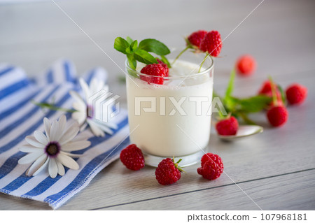 Sweet cooked homemade yogurt with fresh raspberries in a glass. 107968181
