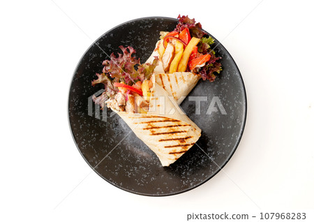 Gyros souvlaki wraps in pita bread with chicken, potatoes and sauce isolated Gyros souvlaki wraps in pita bread with chicken, potatoes and sauce isolated 107968283