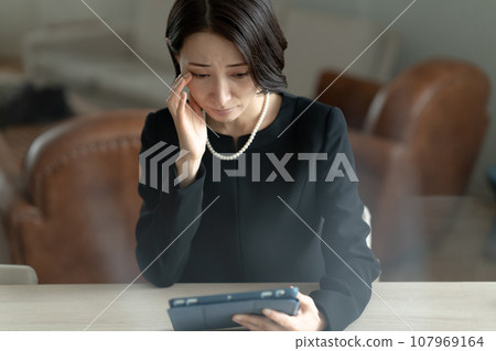 一名婦女透過看平板電腦回憶死者 107969164