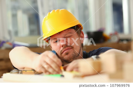 Arms of worker measuring wooden bar 107969976