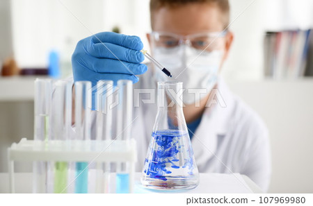 A male chemist holds test tube of glass 107969980