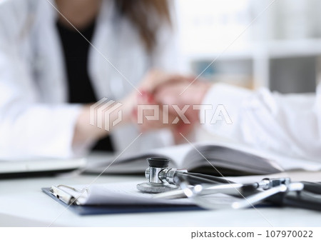 Stethoscope head lying on medical forms closeup 107970022