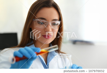 Technician hold in arms in protective gloves sample bottle 107970032