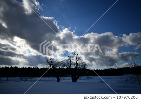 Lonely snowfield scenery under thick clouds illuminated by the sun under a blue sky Lonely snowfield scenery under thick clouds illuminated by the sun under a blue sky 107970206