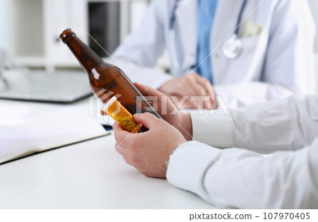 Alcoholic hold in hand empty bottle Alcoholic hold in hand empty bottle 107970405