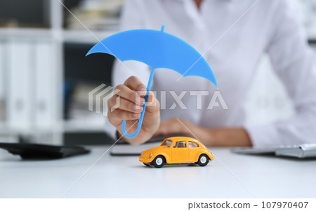 The female hand holds a miniature umbrella The female hand holds a miniature umbrella 107970407