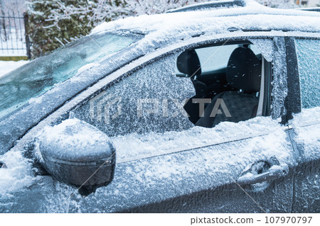 frozen car after snowstorm with broken window frozen car after snowstorm with broken window 107970797