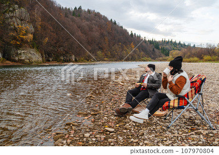 happy couple having picnic at river beach happy couple having picnic at river beach 107970804
