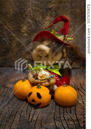 Halloween card. Pumpkins and witch toy with garlic, berry, money and flower. Trick or treat. Dark background Halloween card. Pumpkins and witch toy with garlic, berry, money and flower. Trick or treat. Dark background 107970978