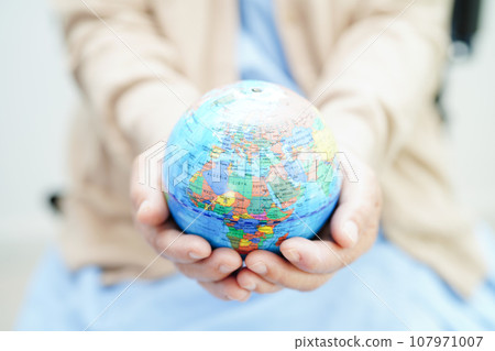 Bangkok, Thailand April 1, 2023 Asian elderly woman patient holding globe in hand at hospital. Bangkok, Thailand April 1, 2023 Asian elderly woman patient holding globe in hand at hospital. 107971007