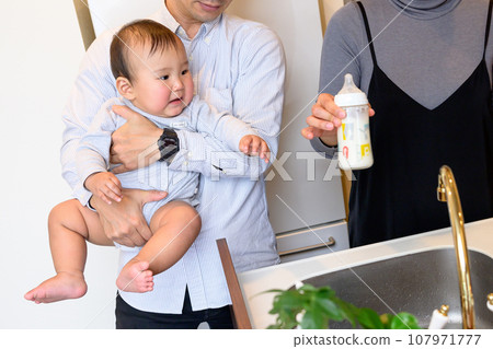被父親抱著讓寶寶喝冰牛奶的母親、被父親抱著的嬰兒、Ikumen 的孩子、0 歲的嬰兒。 107971777