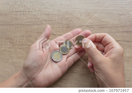 Euro coins in hand close up. Euro coins in hand close up. 107971957