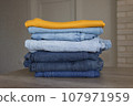 A neatly folded stack of clothes after washing. 107971959