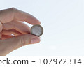 1 euro coin in hand closeup. Cash coin in hand on a white background. 107972314