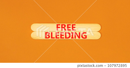Free bleeding symbol. Concept words Free bleeding on wooden stick. Beautiful orange table orange background. Gen Z, motivational, freedom free bleeding concept. Copy space. 107972895