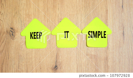 Keep it simple symbol. Concept word Keep it simple on beautiful yellow paper house. Beautiful wooden table wooden background. Business motivational keep it simple concept. Copy space. 107972928