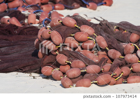 red fishing net on sandy closeup 107973414