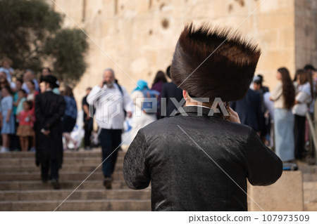 Back view of an Orthodox Jewish man Hasidim with a large fur hat and in a black suit Back view of an Orthodox Jewish man Hasidim with a large fur hat and in a black suit 107973509
