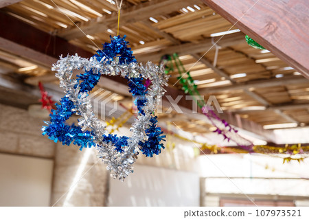 Star of David made from blue and silver tinsel on Sukkot holiday Star of David made from blue and silver tinsel on Sukkot holiday 107973521