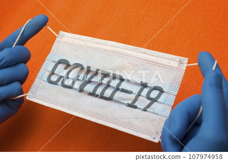 Hands in medical gloves protective mask - quarantine, coronavirus, lettering covid19 107974958