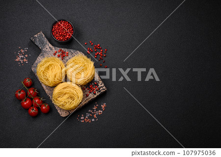 Raw capellini pasta or noodles with salt and spices Raw capellini pasta or noodles with salt and spices 107975036