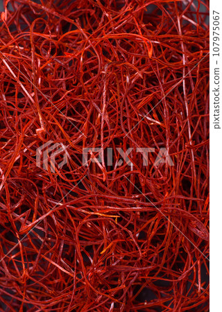 Red thin hot chili threads on a dark background Red thin hot chili threads on a dark background 107975067