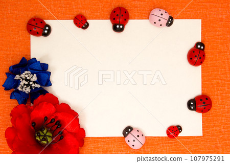 Frame of bright artificial flowers and ladybirds - a multi-colored, background 107975291