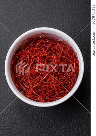 Red thin hot chili threads on a dark background Red thin hot chili threads on a dark background 107975318