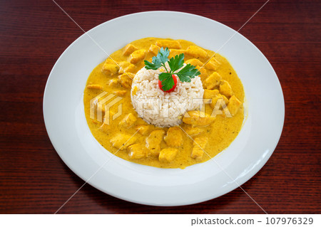 Classic chicken beef stroganoff with rice, and cherry tomato with parsley leaves and turmeric spices 107976329