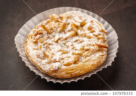 Traditional Portuguese almond tart with caramel and powdered sugar. Close up 107976333