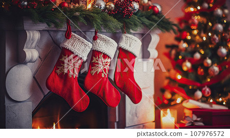Christmas holiday background. Traditional red socks on the fireplace near the Christmas tree. 107976572