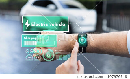Businessman check EV car battery status on smartwatch hologram. Peruse Businessman check EV car battery status on smartwatch hologram. Peruse 107976748