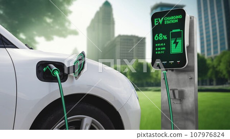 Electric car plugged in with charging station to recharge battery. Peruse 107976824