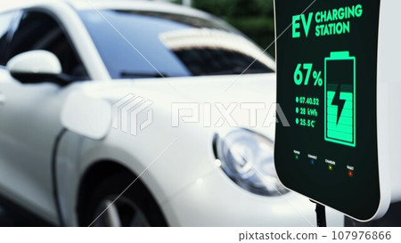 Electric car connected to charging station at public car park Peruse 107976866