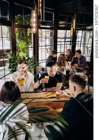 Happy group of friends drinking and clinking with beer and cocktails at brewery bar restaurant 107978367