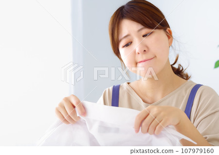 年輕女人看著她的髒襯衫 107979160